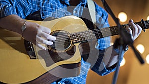 Musician playing acoustic guitar on stage