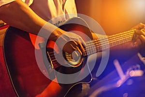 Musician playing acoustic guitar on stage music band in the night at nightclub