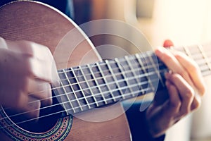 Musician is playing a classical guitar, fretboard and fingers