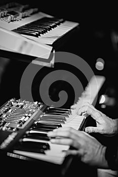 Musician playing on the double keyboard synthesizer piano keys. Musician plays a musical instrument on the concert stage