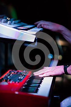 Musician playing on the double keyboard synthesizer piano keys. Musician plays a musical instrument on the concert stage