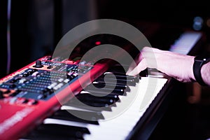 Musician playing on the double keyboard synthesizer piano keys. Musician plays a musical instrument on the concert stage