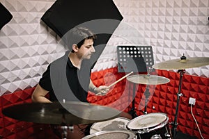 Musician playing drum kit in music studio