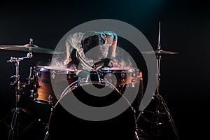 Musician playing drums with splashes, black background with beautiful soft light