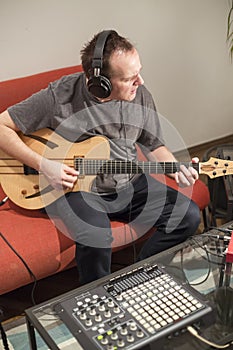 Musician playing electric guitar in home music studio