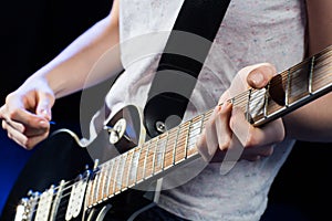 Musician playing electric guitar with mediator