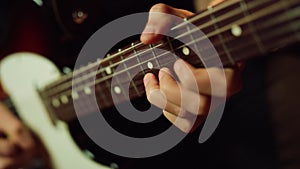 Musician playing electric guitar in studio. Guitarist hand pinching chords