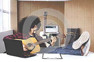 Musician with hands in guitar inside recording studio