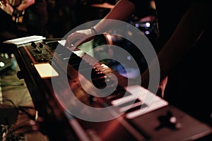 Musician playing on the keyboard synthesizer piano keys. Musician plays a musical instrument on the concert stage