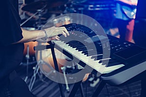 Musician playing on the keyboard synthesizer piano keys. Musician plays a musical instrument on the concert stage