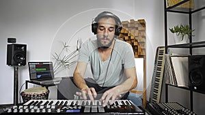 Musician playing midi keyboard in home music studio.