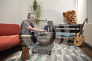 Musician playing midi keyboard in home music studio