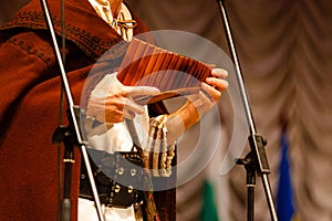 Musician playing panpipe. Musical instrument rondador or pan flute. Man playing flute during ethnic music concert