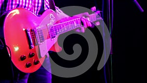 A musician playing red guitar closeup