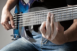 Musician playing on six-string bass guitar