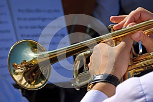 Musician playing trumpet in street orchestra