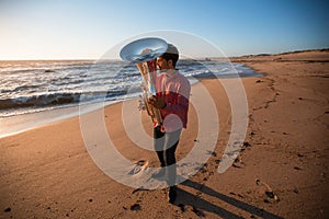 Musician playing the Tuba on the sea coast. Hobby.