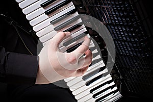 Musician plays the accordion against a dark background