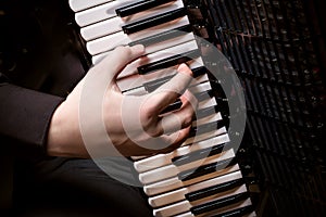 Musician plays the accordion against a dark background photo