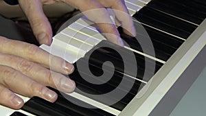 The musician plays on a digital piano. Hands of the pianist. A synthesizer or electronic piano