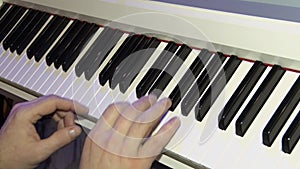 The musician plays on a digital piano. Hands of the pianist. A synthesizer or electronic piano