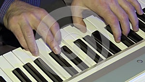 The musician plays on a digital piano. Hands of the pianist. A synthesizer or electronic piano