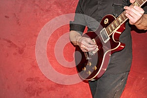 Musician plays with a Gibson Les Paul american standard electric guitar in red