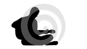 Musician plays the lyric song on the guitar and sings. Silhouette. White background