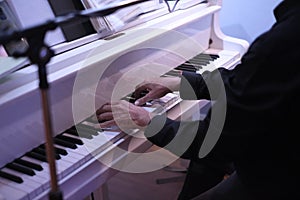 Musician plays  songs with a white piano for dinner