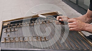 A musician plays string dulcimer on the street.