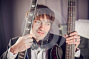 Musician portrait in studio with two guitars