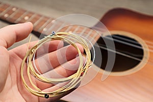 The musician replace the new guitar strings. The man's hand holding new music strings. Music theme