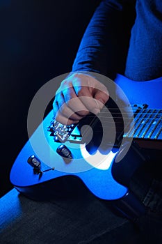Musician rock guitarist playing a blue guitar