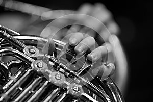 Musician's fingers playing the french horn