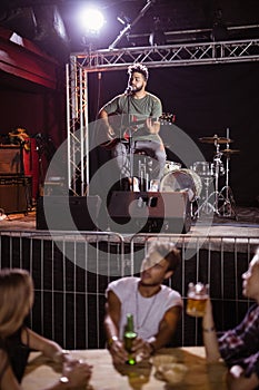 Musician singing with fans sitting at table