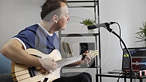 Musician singing and playing electric guitar in home music studio.