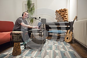 Musician singing and playing midi keyboard in home music studio