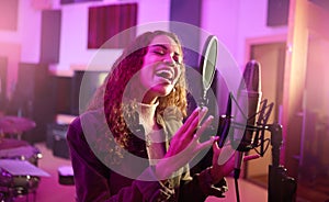 Musician, singing or woman on neon studio microphone, music equipment or practice in night theatre recording. Singer