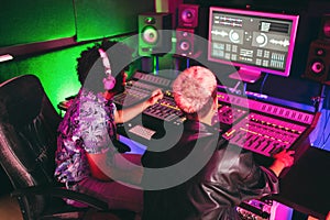Musician and sound engineer mixing new album inside boutique recording studio - Technology and music industry concept - Main focus