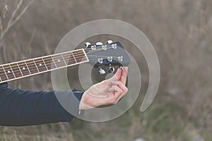 Musician tune the strings of an elegant black guitar, Spain