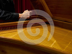 Musician tunes historical harpsichord cembalo with his hands before the concert.