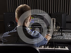 Musician working and producing music in his modern sound studio
