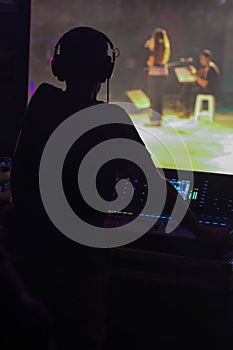 Musicians, operator and console on stage of a concert.