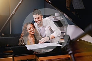 Musicians, piano and people writing music in a creative or recording studio with a song book. Art, creativity and couple