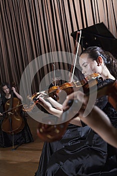 Musicians playing during a performance, violinists at the front