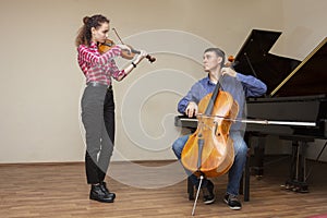 Musicians of the symphony orchestra. Young violinist and cellist in concert costumes