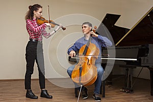 Musicians of the symphony orchestra. Young violinist and cellist in concert costumes