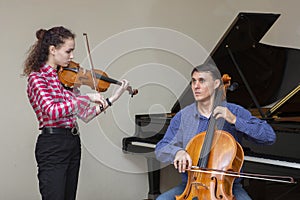 Musicians of the symphony orchestra. Young violinist and cellist in concert costumes