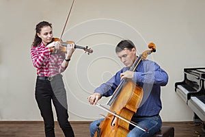 Musicians of the symphony orchestra. Young violinist and cellist in concert costumes