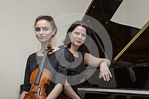 Musicians of the symphony orchestra. Young violinist and pianist in concert dresses